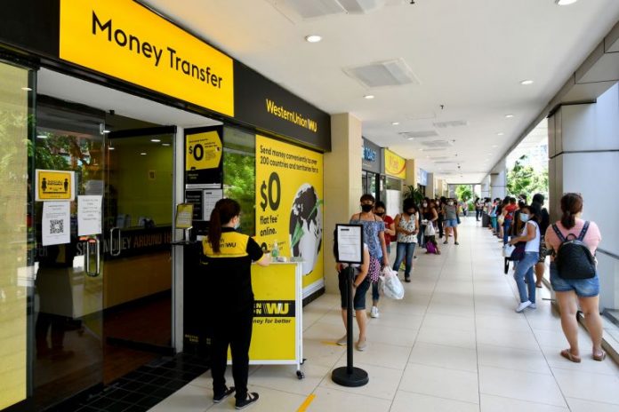 Appointment needed for remittance at hotspots - People queueing to remit money at the Western Union branch in Lucky Plaza on May 31, 2020.ST PHOTO: LIM YAOHUI